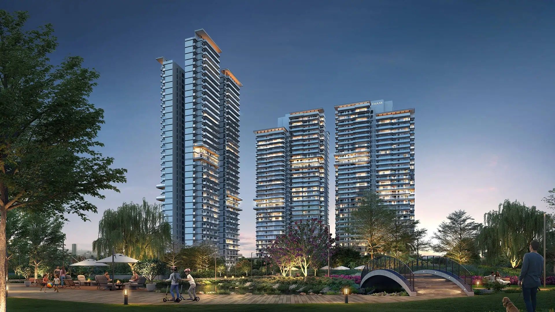 Artist's impression of the Serenity Hills towers at dusk, seen across the landscaped central greens and a footbridge.